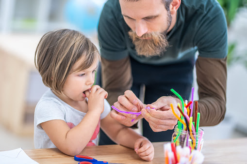 Male teacher and child in classroom.